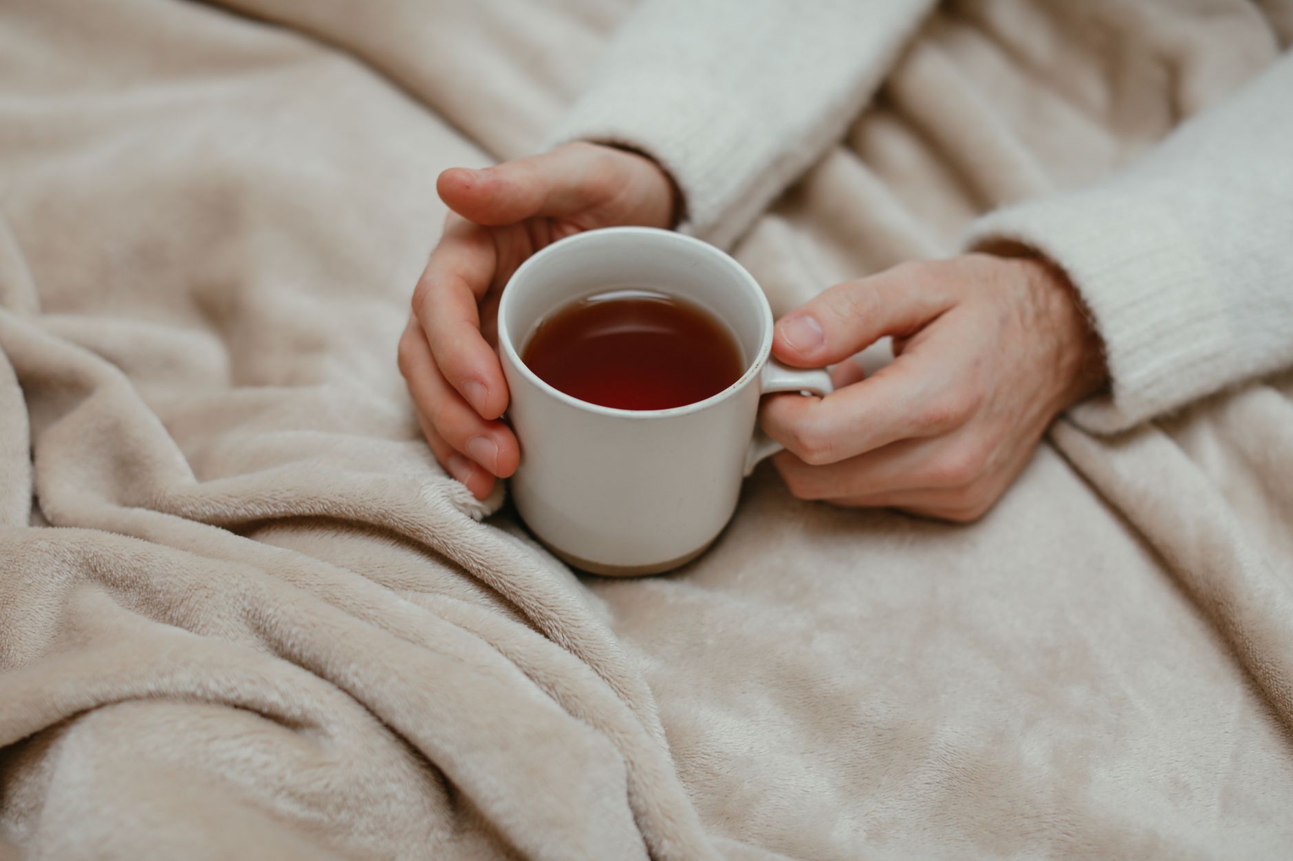 Close-up of hands resting on a weighted blanket, relevant to weighted blanket evidence UK for anxiety relief